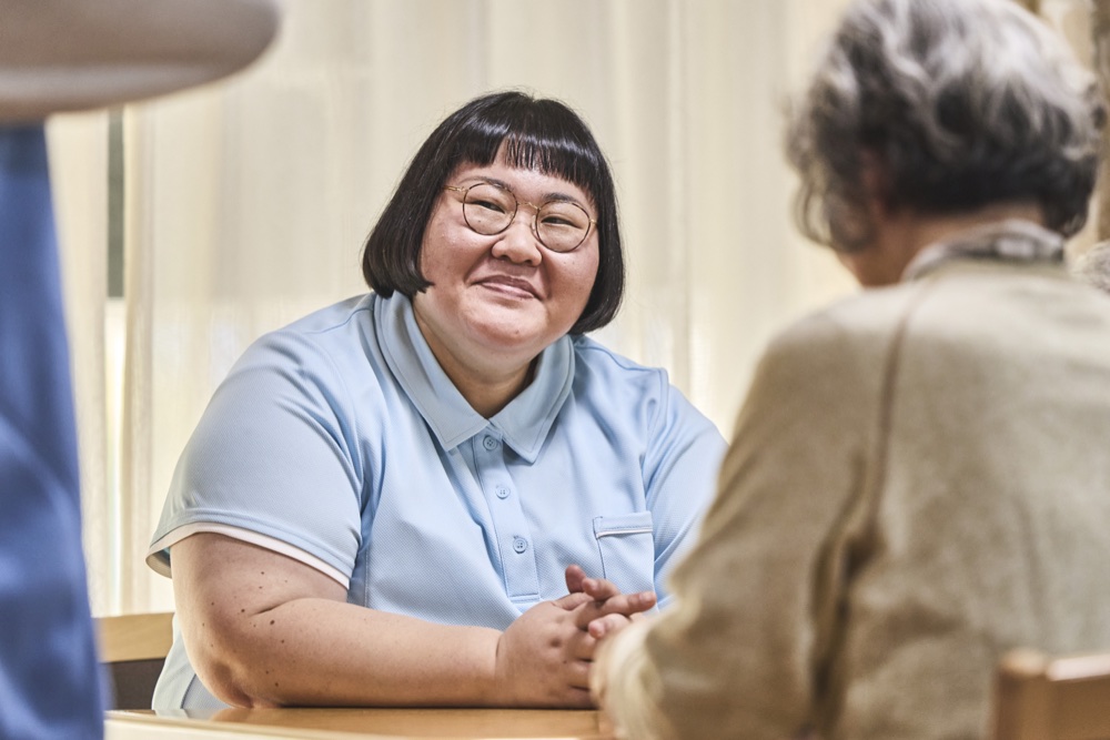 戸田伊月を演じる安藤なつ。入居者に笑顔で語りかける。