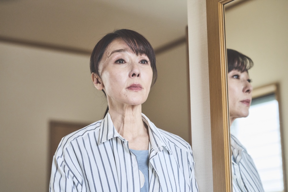 茂木陽子を演じる浅野ゆう子。鏡の前で静かに佇む。